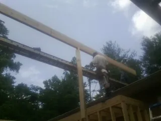 Carpenter setting a ridge beam over a new addition frame — Ice Dam Removal by Roofing Brothers in Round Hill