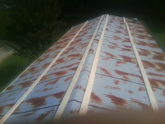 Rusted metal roof panels with new wood purlins before replacement — Storm Damage Roof Repair in Round Hill by Roofing Brothers