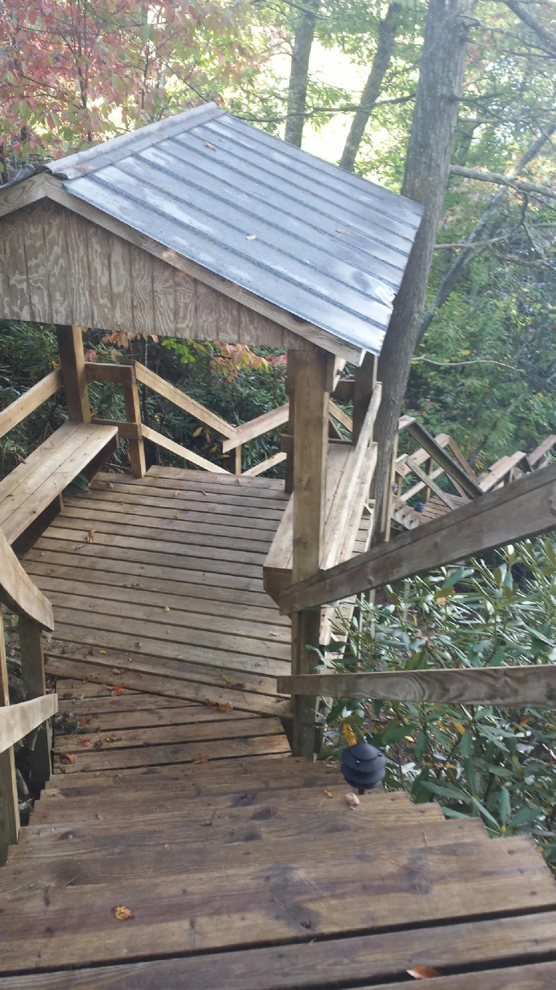 Metal roofed shelter over wooden steps on a wooded walkway — Skylight Repair & Installation work by our crew in Round Hill