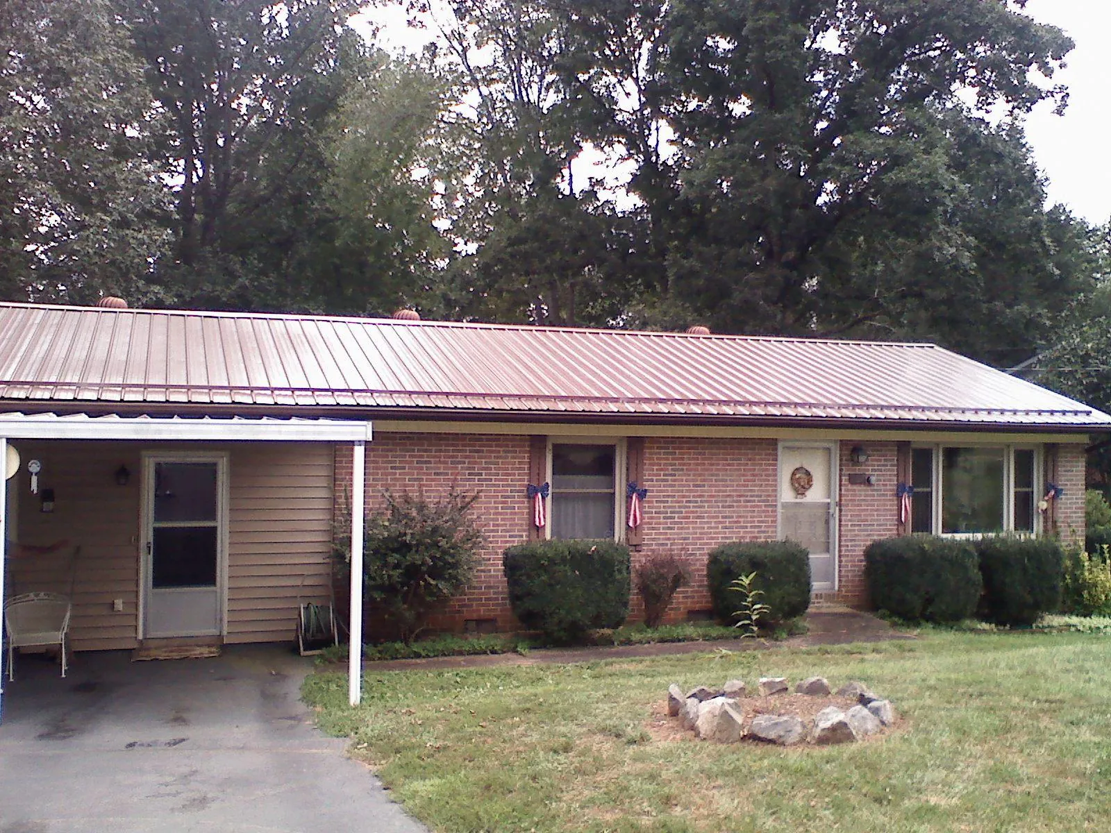 Bronze metal roof and carport on a brick ranch home — Roof Repair work by our crew in Round Hill